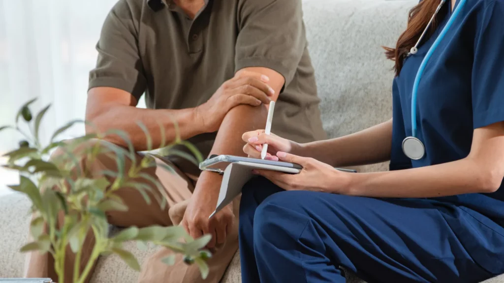 Coordinatrice de parcours prenant des notes lors d’un entretien avec un patient